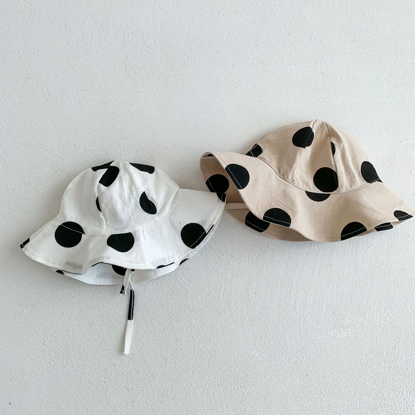 Front view of baby wearing Polka Pop jumpsuit and hat β Ju Ju Jam