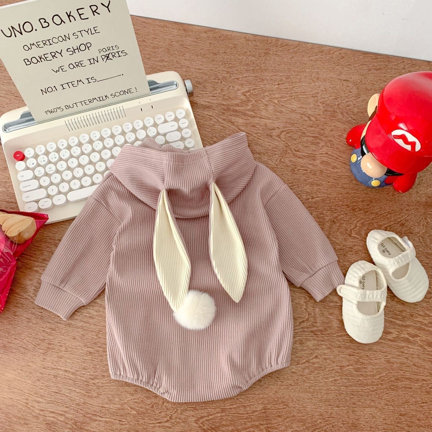 Unisex baby onesie with hood and rabbit tail β soft and playful outfit from Ju Ju Jam.