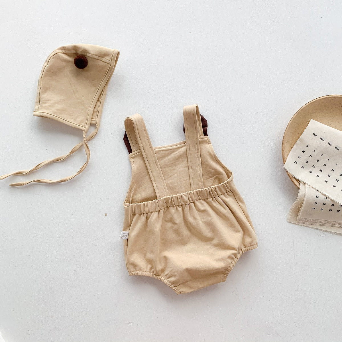 Laid flat Tiny Teddy Romper With Hat – two-piece baby outfit with teddy bear design