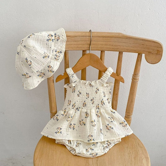 Baby girl in Lily Elegant Romper Dress with Hat – pastel floral design, soft fabric, and charming style – Ju Ju Jam baby clothing.