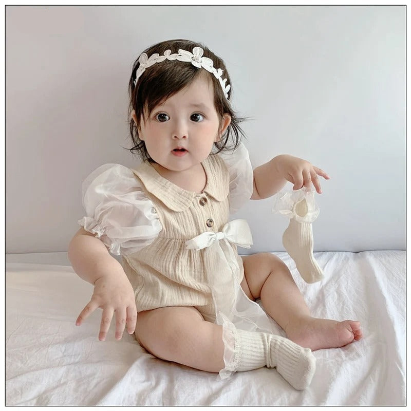 Adorable baby girl wearing a My Lady romper with a bow detail from Ju Ju Jam.