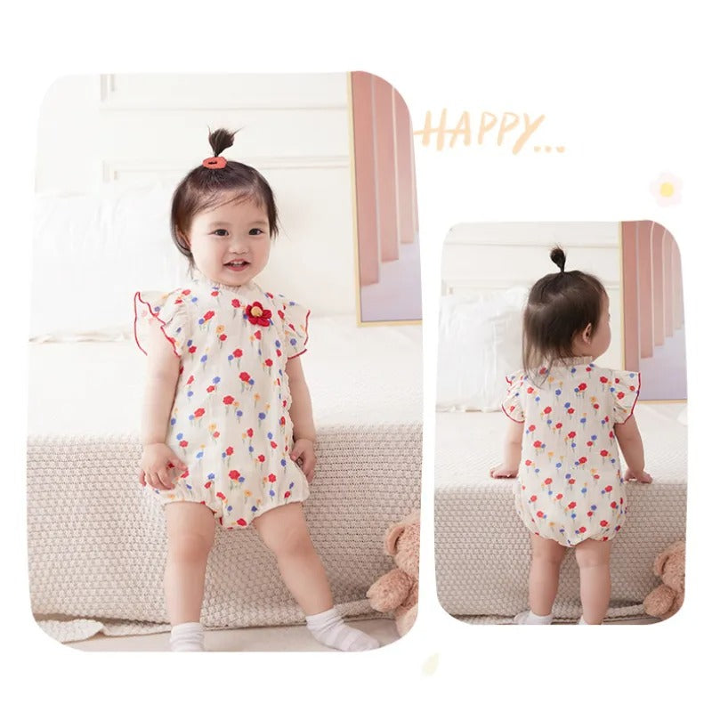 Charming baby girl in a romper with a red flower attachment, designed for elegance from Ju Ju Jam.