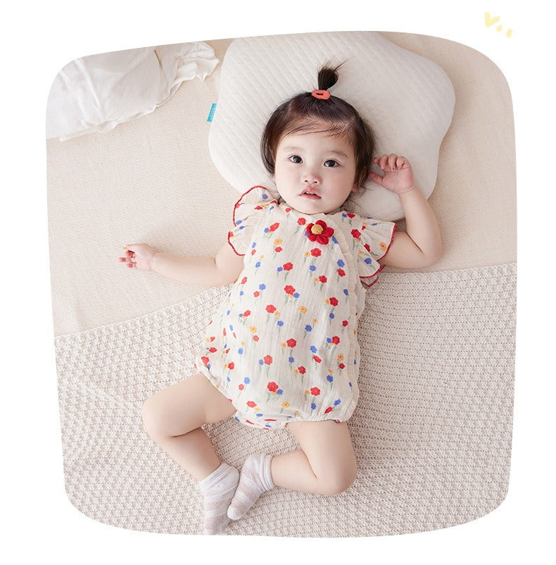 Infant wearing a Red Flower Attached romper with a vibrant flower design from Ju Ju Jam.