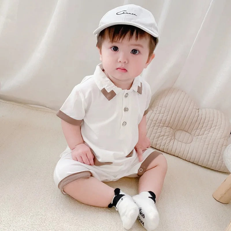 Sweet baby boy in a White Collared romper, designed for elegance from Ju Ju Jam.