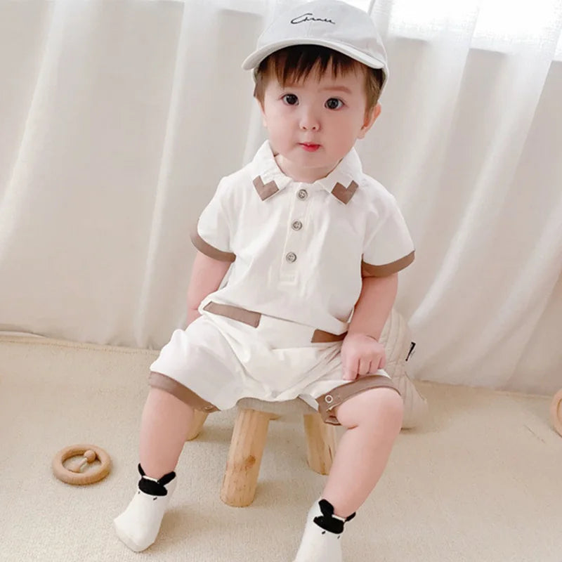 Baby boy in a crisp White Collared romper with a classic collar detail from Ju Ju Jam.