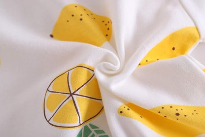 Adorable baby wearing a Yellow Lemon romper with cheerful lemon patterns, from Ju Ju Jam.