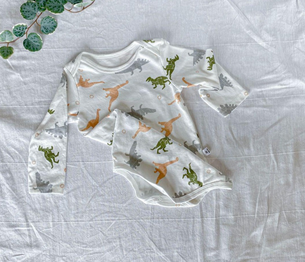 Cute baby in a dinosaur-themed romper from Ju Ju Jam